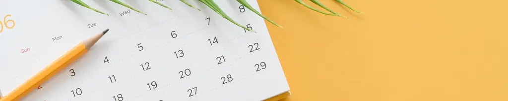 Agenda mit Stift vor gelbem Hintergrund